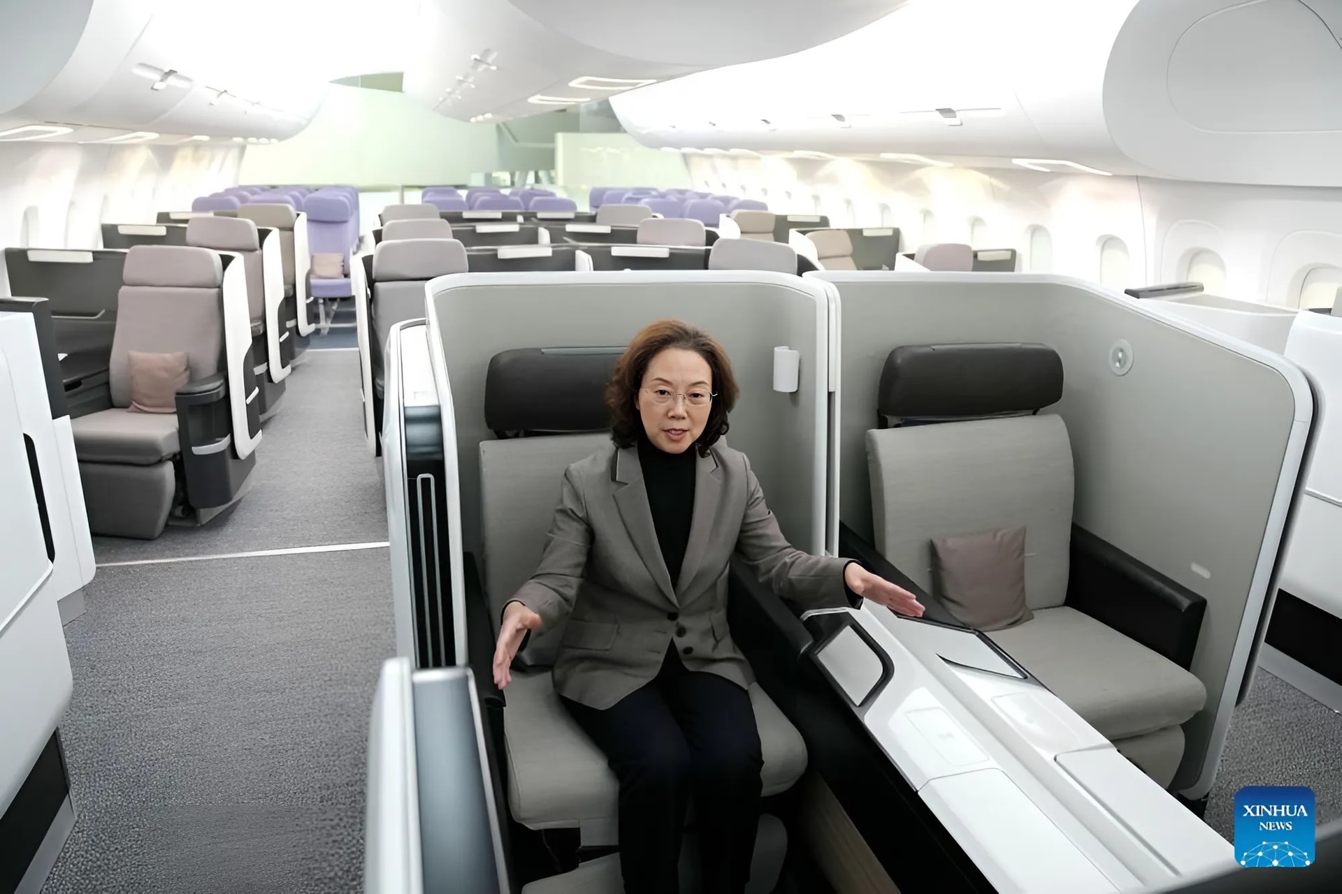 Bà Triệu Xuân Linh giới thiệu thiết kế cabin bên trong mô hình máy bay C929 tại Viện nghiên cứu của COMAC ở Thượng Hải. Ảnh: Xinhua.