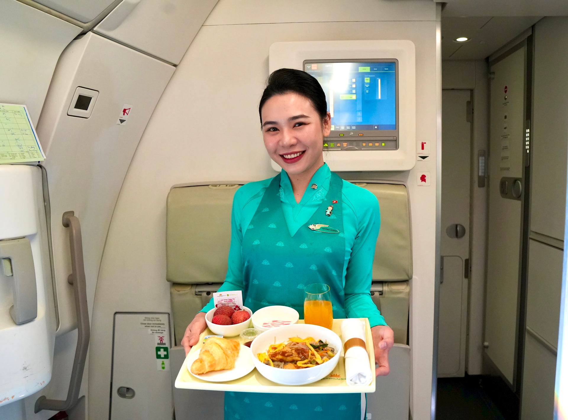 Tiếp viên Vietnam Airlines phục vụ suất ăn đặc biệt với vải trừng Hưng Yên – nông sản đạt chuẩn VietGAP, OCOP 4 sao – trong chiến dịch quảng bá ẩm thực vùng miền trên không