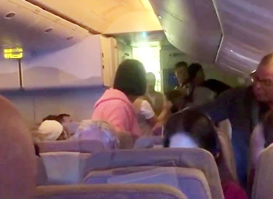Passengers restraining an unruly passenger on an Emirates flight.