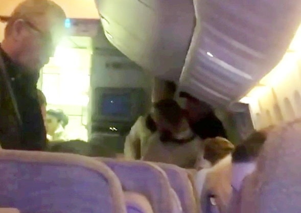 A disruptive passenger being restrained on an Emirates flight.
