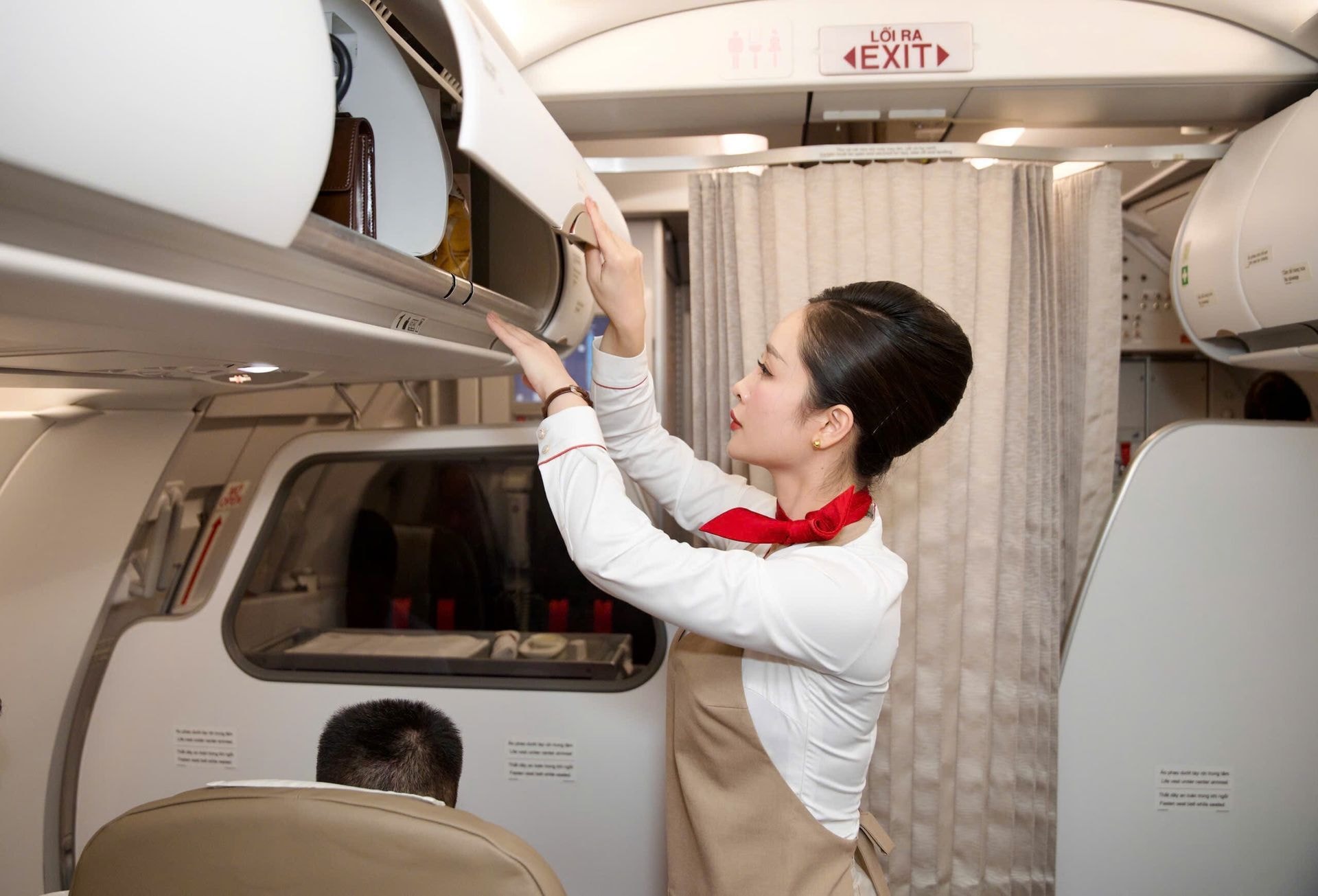 Việc hành khách mang nhiều hành lý xách tay lên cabin có thể dẫn đến tình trạng quá tải hoặc thời gian lên xuống tàu lâu, dẫn đến chậm chuyến. Trong ảnh, tiếp viên hàng không của Sun PhuQuoc Airways kiểm tra khu vực để hành lý xách tay của khách trên cabin.