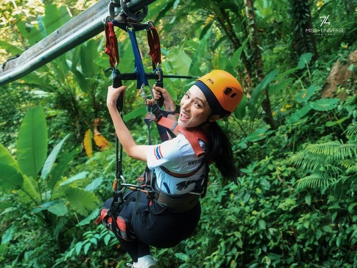 Tại đây, cô và các thí sinh trải nghiệm đường zipline dài 800 m với tốc độ 40 km/h, lướt qua những tán cây xanh mát. Đây là đường zipline dài và nhanh nhất Thái Lan. Với những tín đồ cảm giác mạnh, Roller Zipline với các khúc cua ngoằn ngoèo mang đến trải nghiệm hồi hộp, đáng nhớ. Ảnh: Miss Universe.
