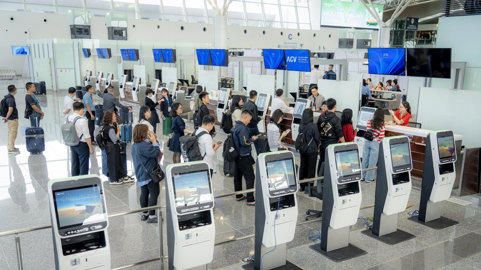 Cán bộ nhân viên sân bay đóng giả hành khách thực hiện thủ tục xuất cảnh trong chuyến bay giả định tại Nhà ga T2 ngày 4/12. Bên cạnh là các hệ thống kiosk check-in mới.