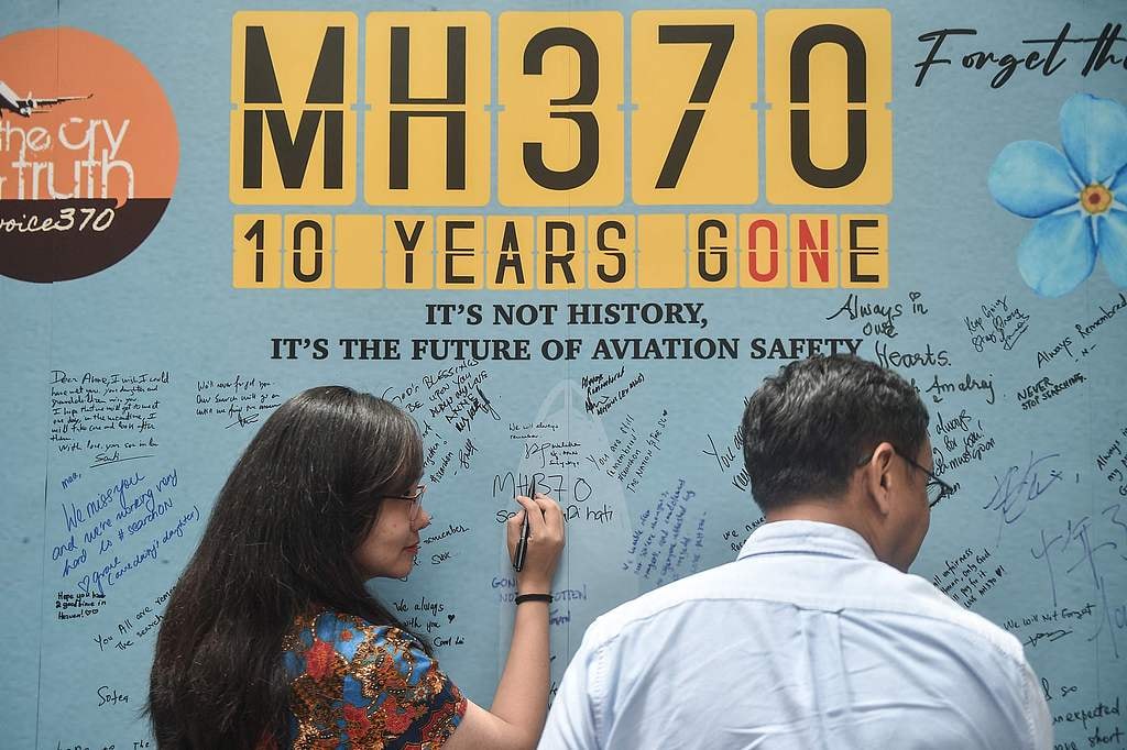 A woman writes a message during an event held by relatives of the passengers and supporters to mark the 10th year since the Malaysia Airlines flight MH370 carrying 239 people disappeared from radar screens on March 8, 2014 while en route from Kuala Lumpur to Beijing, in Subang Jaya on March 3, 2024. /VCG